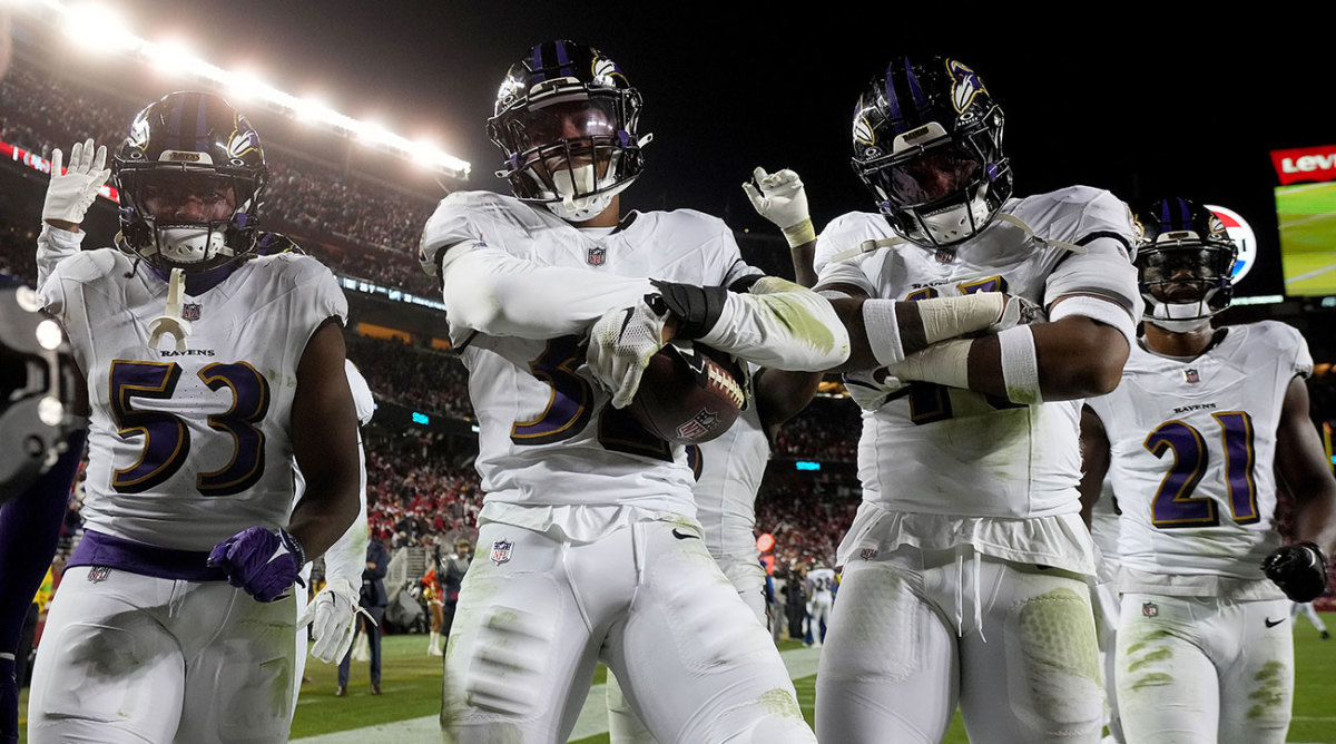 A group of Ravens defenders flex in the end zone after an interception