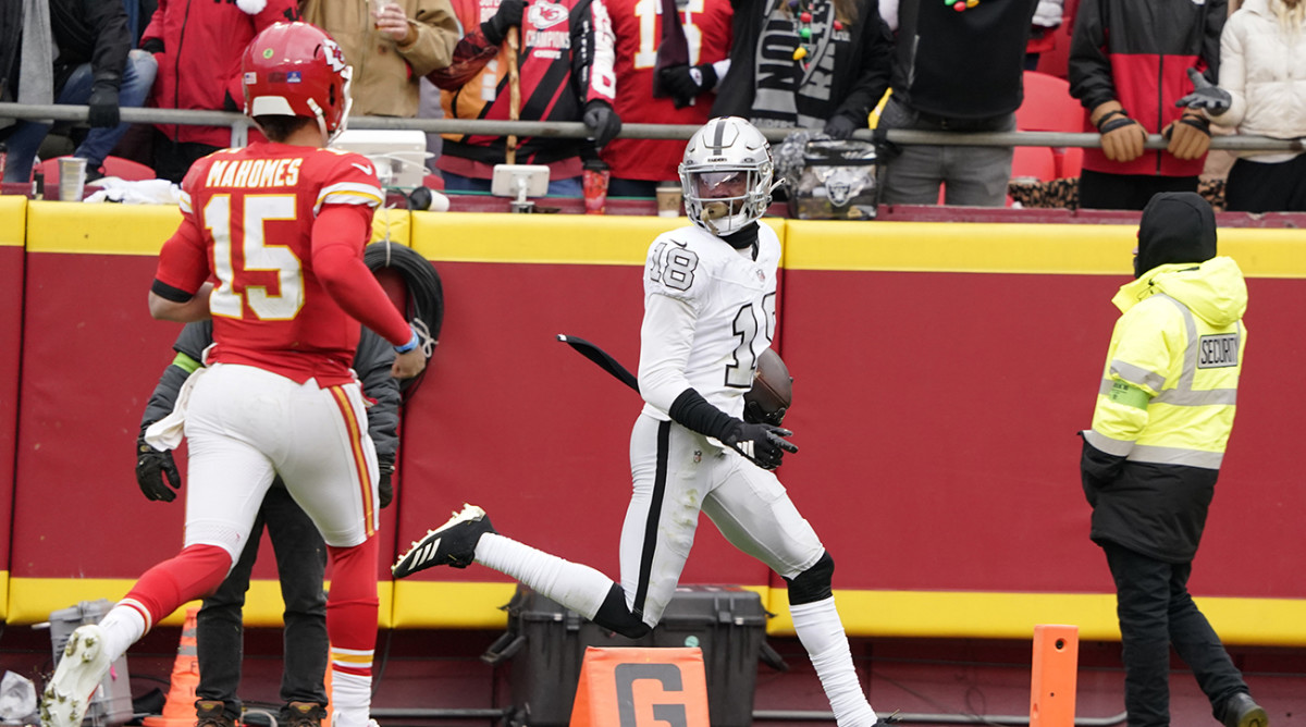 Las Vegas Raiders cornerback Jack Jones scores after intercepting a pass and running it back for a touchdown as Kansas City Chiefs quarterback Patrick Mahomes watches.