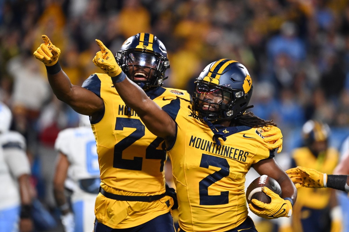 Dec 27, 2023; Charlotte, NC, USA; West Virginia Mountaineers safety Aubrey Burks (2) celebrates with safety Marcis Floyd (24) after intercepting the ball in the end zone in the first quarter at Bank of America Stadium.