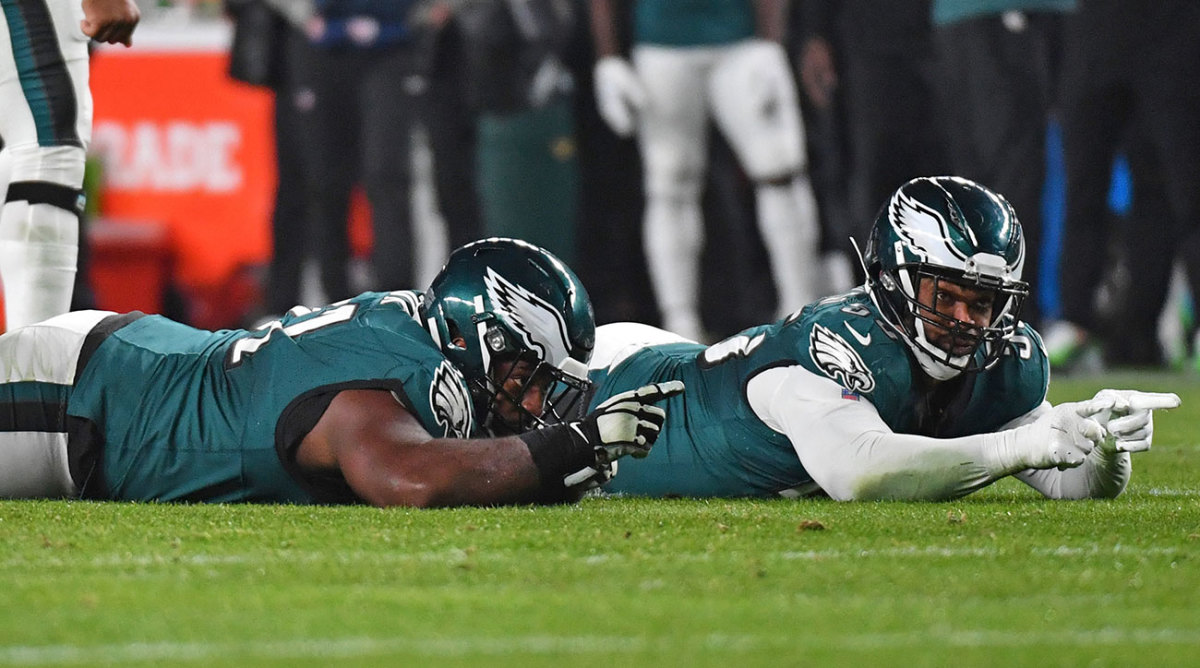 Fletcher Cox and Brand Graham celebrate a sack by lying on the ground and pointing ahead.