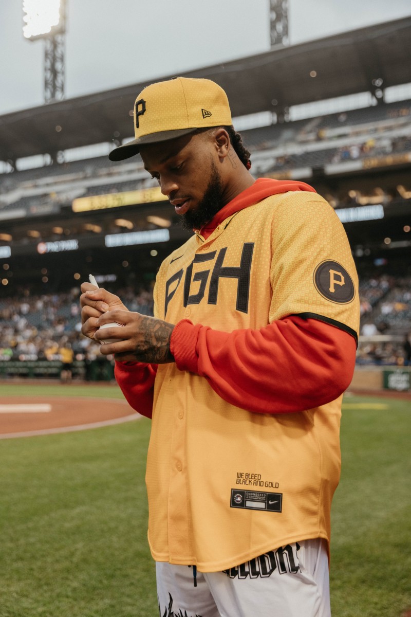 Damar Hamlin signs a baseball wearing Pittsburgh Pirates gear