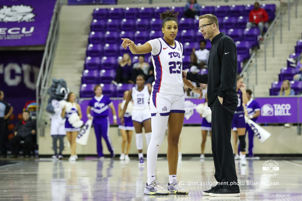 Aaliyah Roberson (23) and coach Mark Campbell discuss on-court action during a game against ACU. 