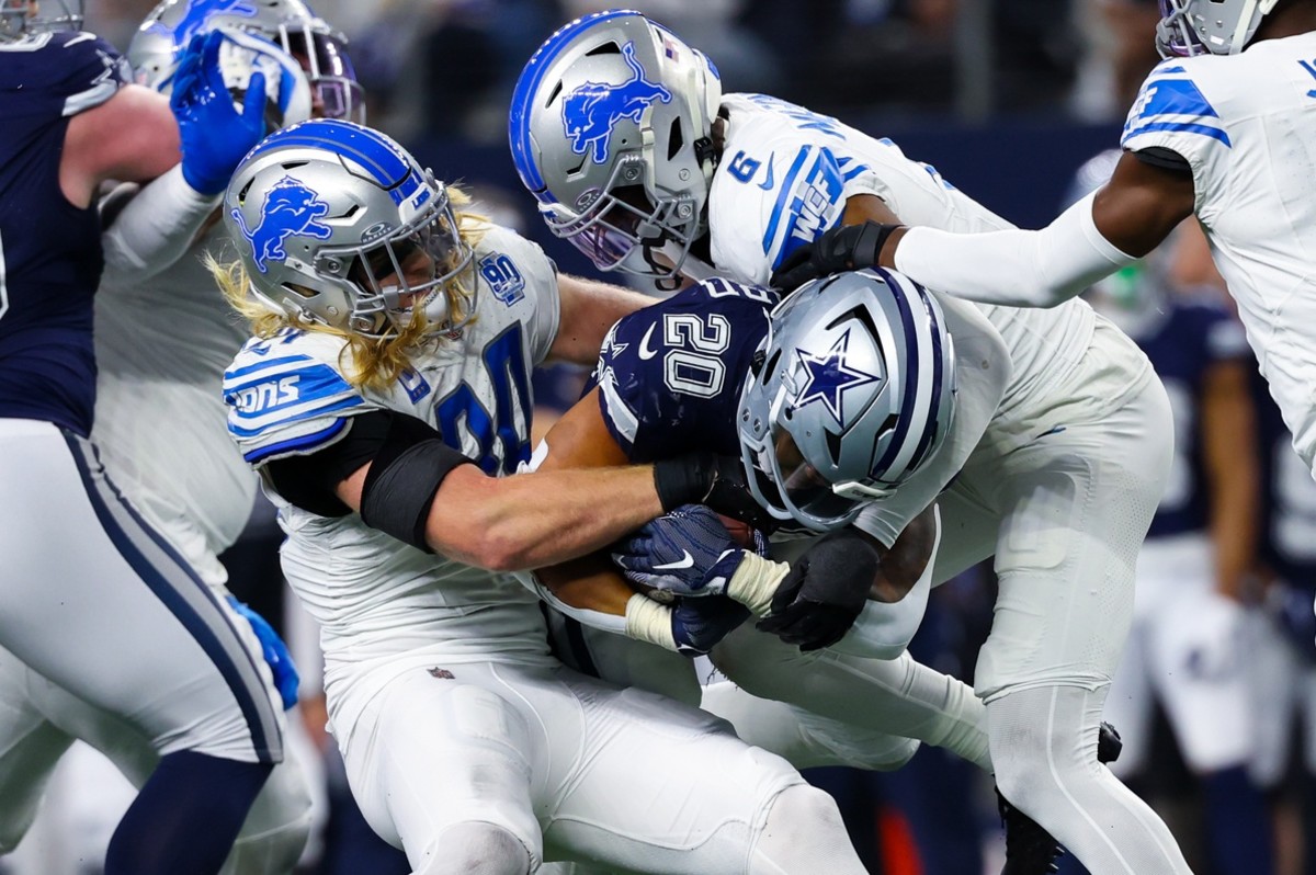 Dec 30, 2023; Arlington, Texas, USA; Dallas Cowboys running back Tony Pollard (20) is tackled by Detroit Lions linebacker Alex Anzalone (34) and Detroit Lions safety Ifeatu Melifonwu (6) during the second half at AT&T Stadium.