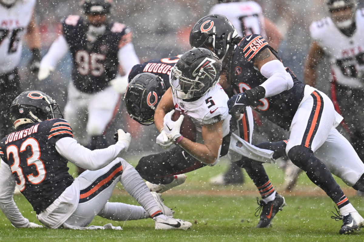 Dec 31, 2023; Chicago, Illinois, USA; Atlanta Falcons wide receiver Drake London (5) is tackled by Chicago Bears defensive back Jaylon Johnson (33), defensive back Kyler Gordon (6) and linebacker Tremaine Edmunds (49) after a short pass gain in the first half at Soldier Field.