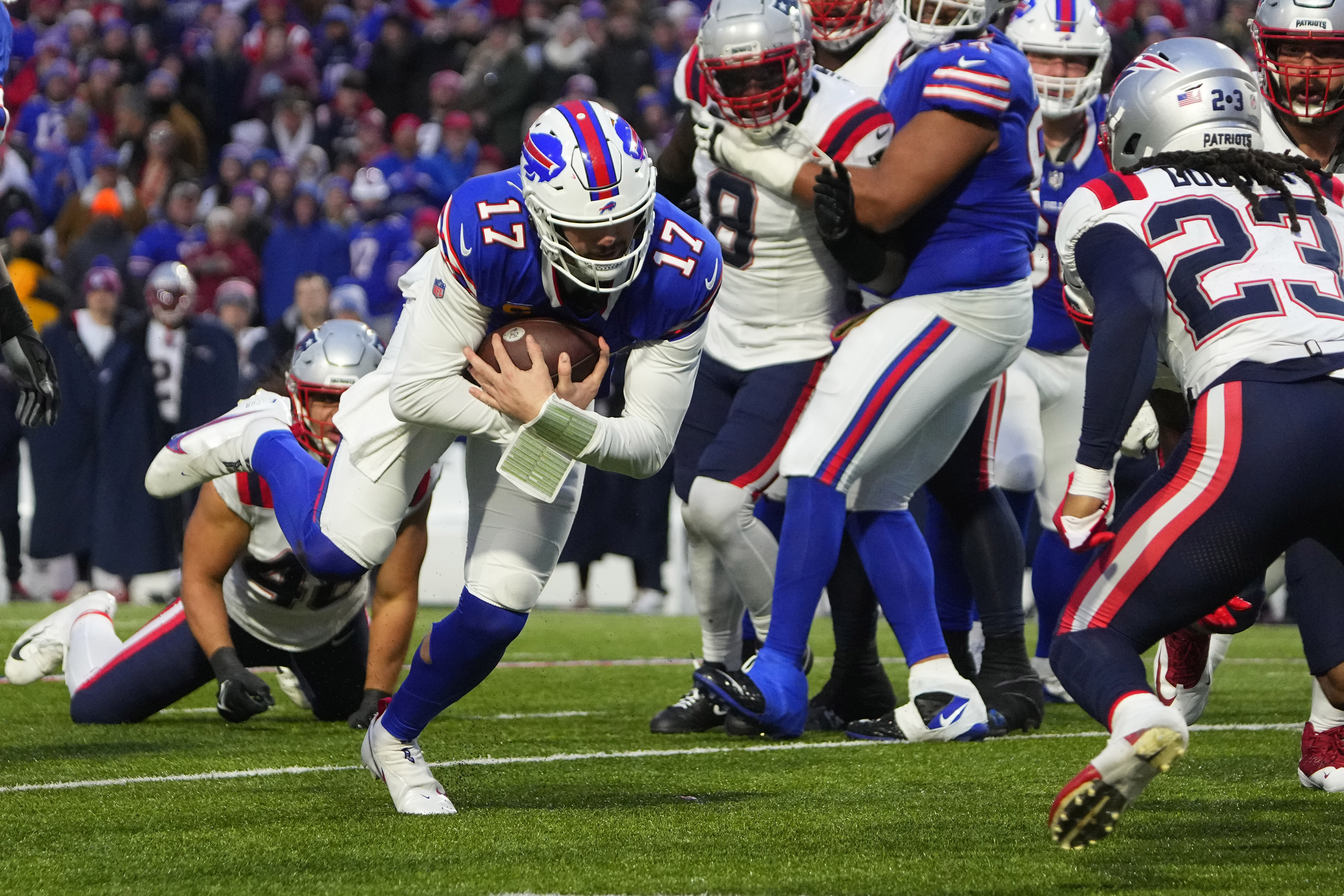 Dec 31, 2023; Orchard Park, New York, USA; Buffalo Bills quarterback Josh Allen (17) runs with the ball for a first down against the New England Patriots during the second half at Highmark Stadium. 