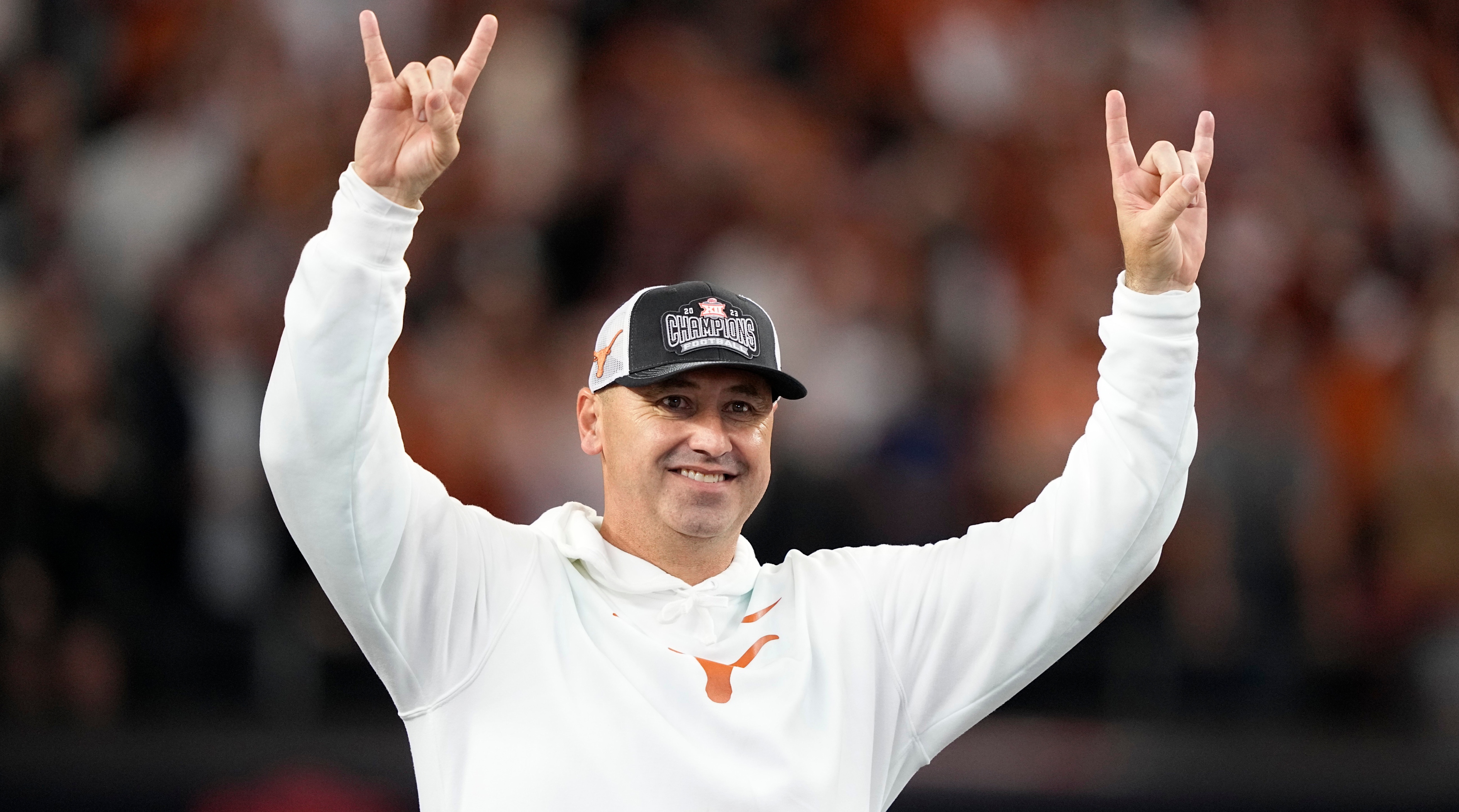 Texas football head coach Steve Sarkisian celebrates his team’s Big 12 championship victory by putting up the ‘Horns’ symbol with both hands.
