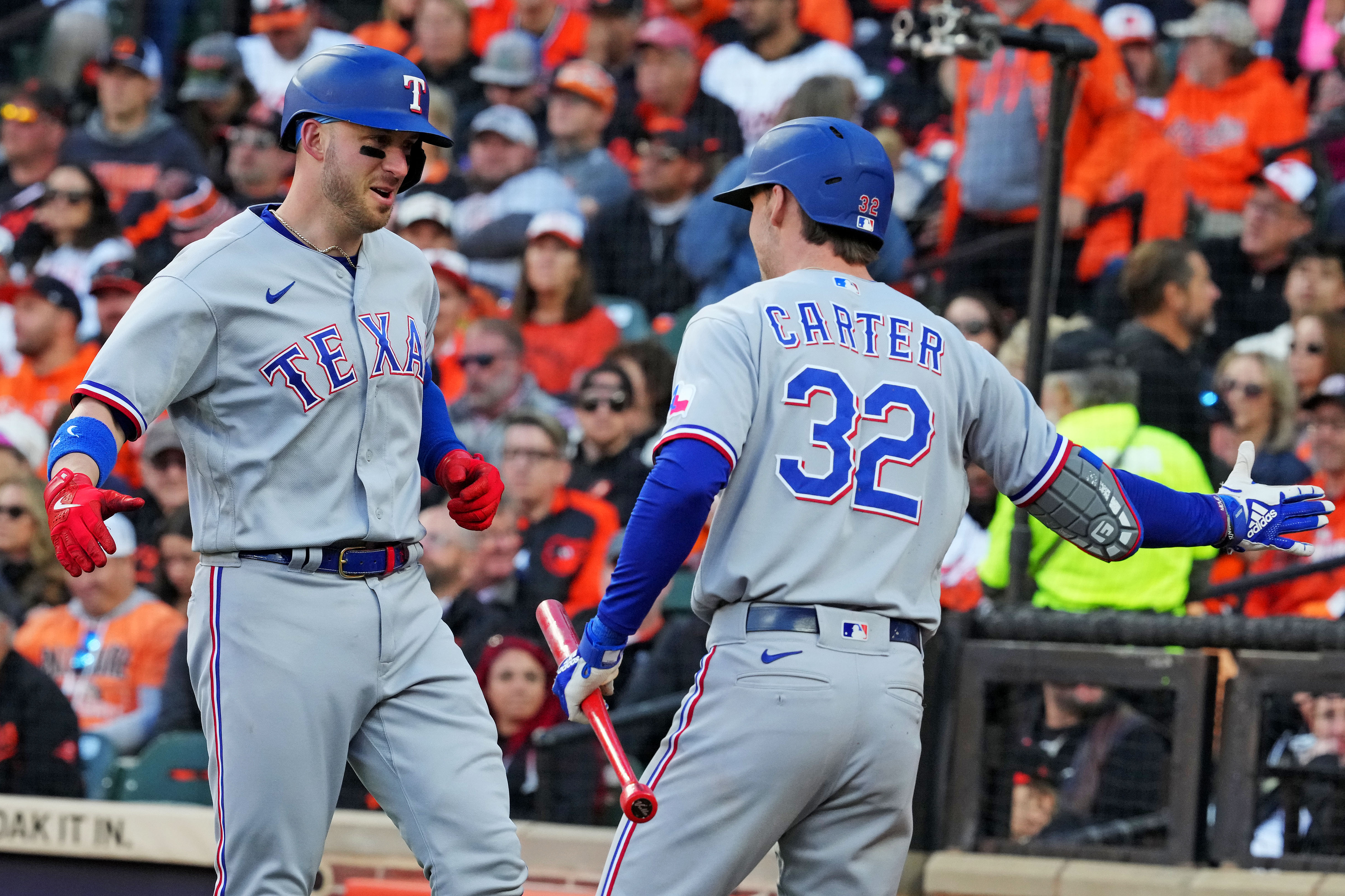 Texas Rangers designated hitter Mitch Garver celebrates with Evan Carter after hitting a grand slam in the third inning against the Baltimore Orioles during Game 2 of the ALDS at Camden Yards.