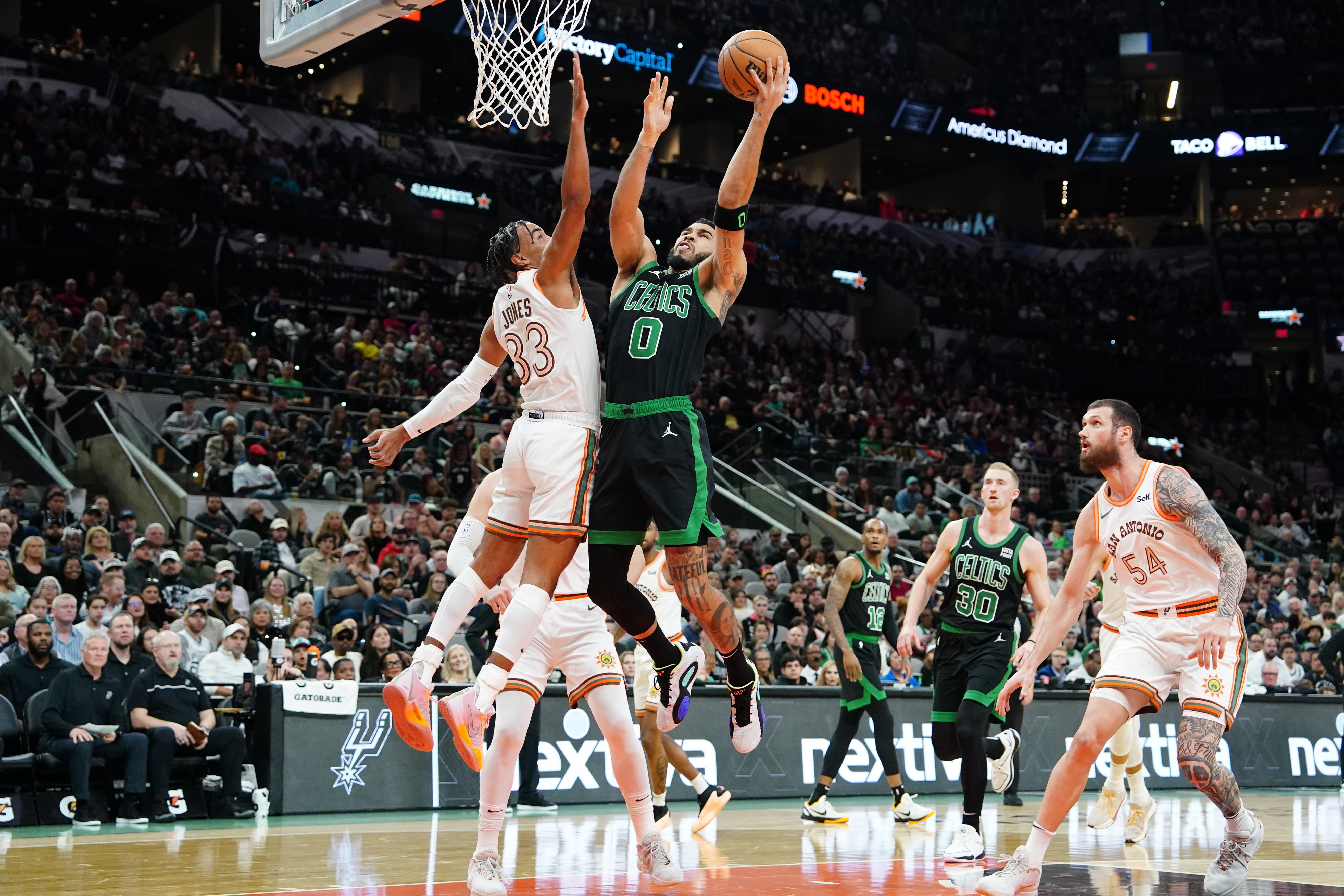 Dec 31, 2023; San Antonio, Texas, USA; Boston Celtics forward Jayson Tatum (0) shoots over San Antonio Spurs guard Tre Jones (33) in the first half at Frost Bank Center.