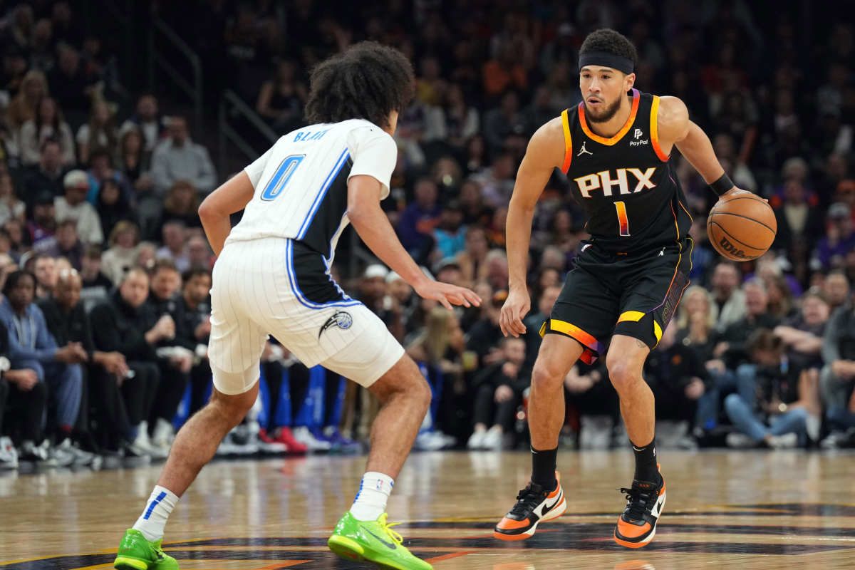 Devin Booker (1) sizes up Orlando Magic's Anthony Black (0).