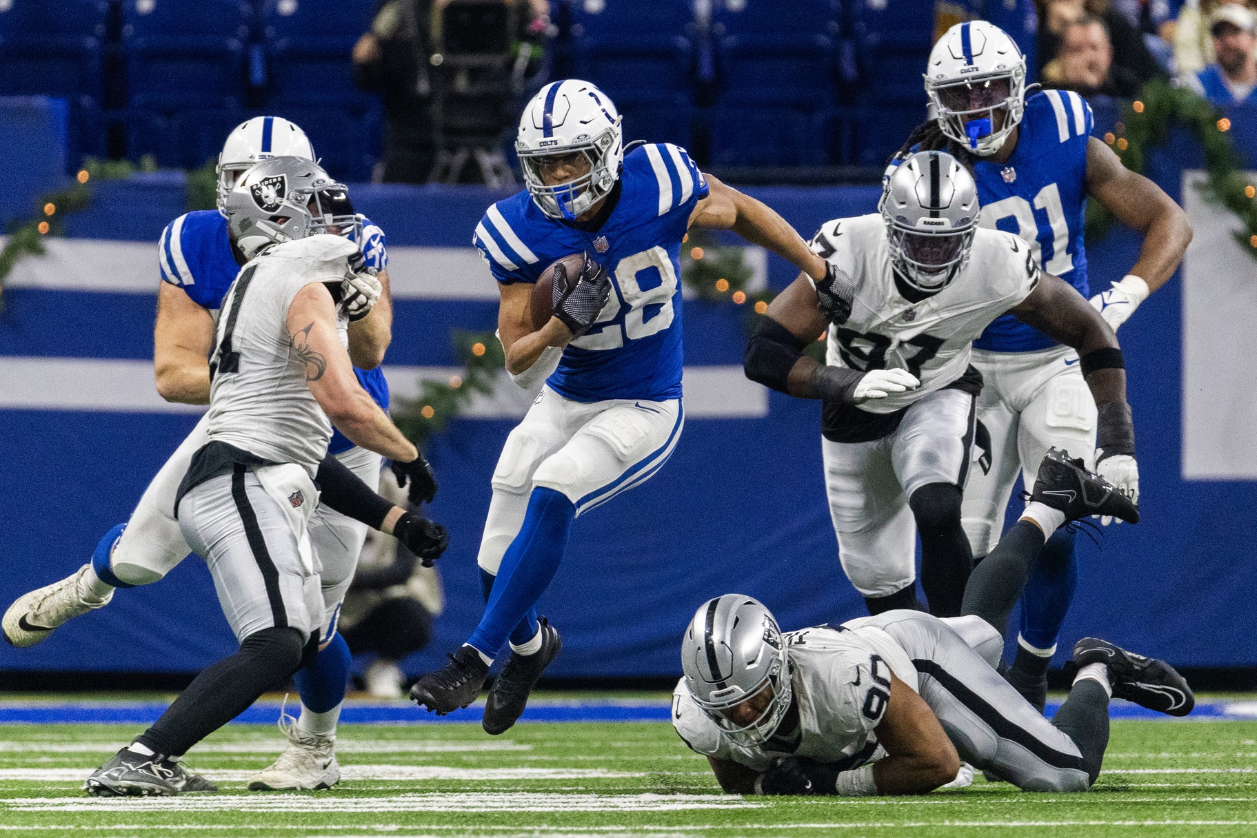 Dec 31, 2023; Indianapolis, Indiana, USA; Indianapolis Colts running back Jonathan Taylor (28) runs the ball while Las Vegas Raiders defensive tackle Jerry Tillery (90) defends in the second half at Lucas Oil Stadium.