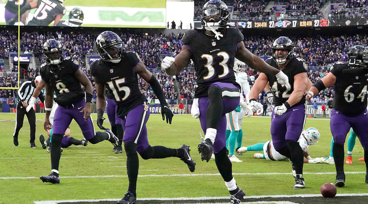 Ravens players run through the end zone together after a touchdown against the Dolphins
