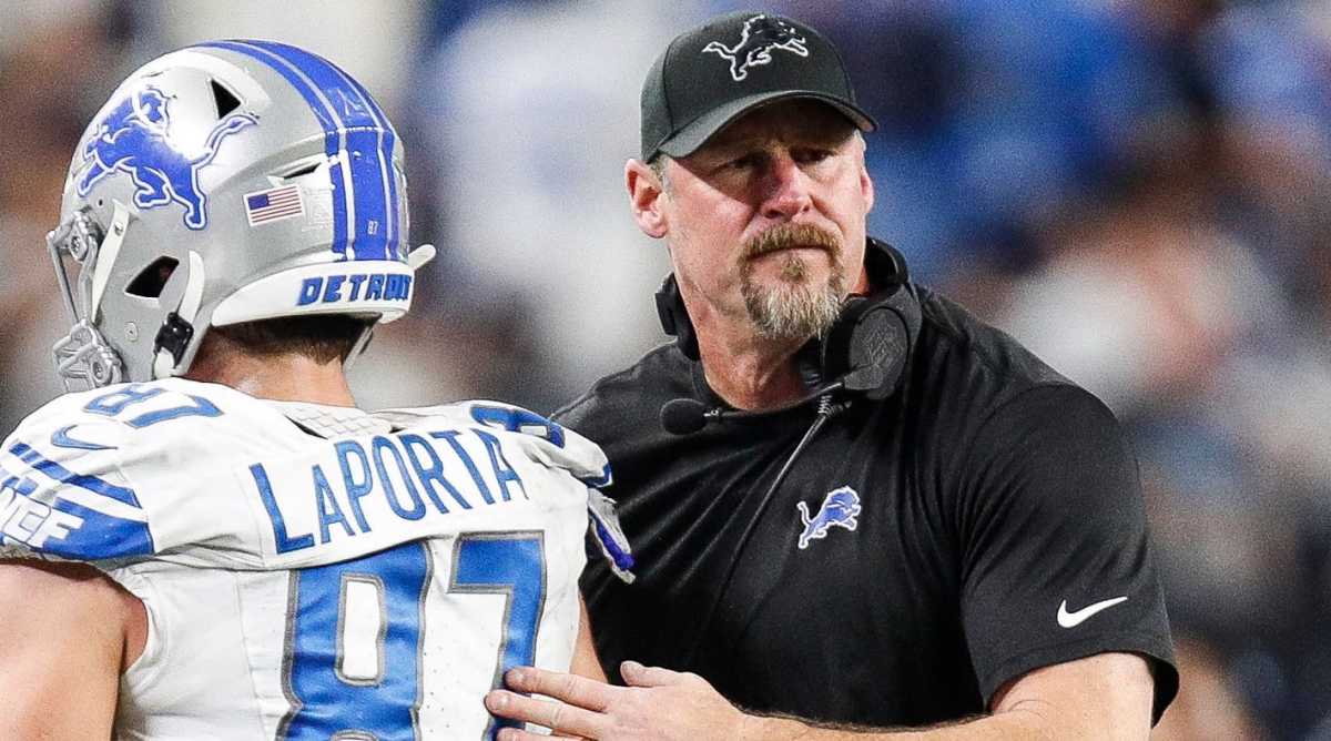 Lions coach Dan Campbell, right, pats the back of tight end Sam LaPorta as he walks off the field.