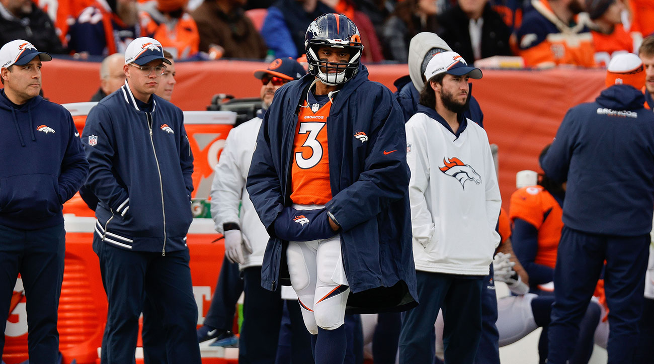 Russell Wilson wearing his helmet and a jacket on the Broncos sideline