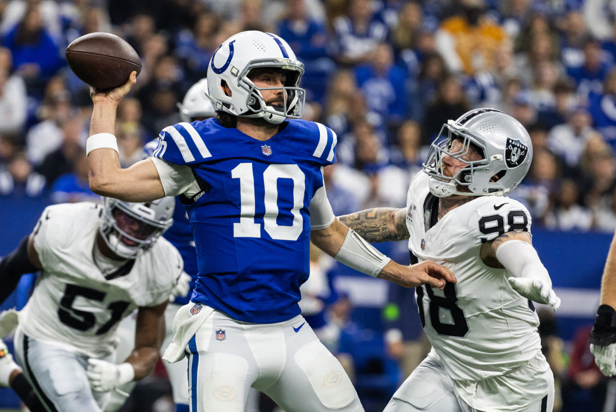 Dec 31, 2023; Indianapolis, Indiana, USA; Indianapolis Colts quarterback Gardner Minshew (10) passes the ball while Las Vegas Raiders defensive end Maxx Crosby (98) defends in the first half at Lucas Oil Stadium. Mandatory Credit: Trevor Ruszkowski-USA TODAY Sports