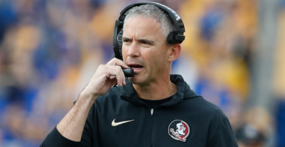 Florida State Seminoles head coach Mike Norvell calls a play on the sideline during a college football game.