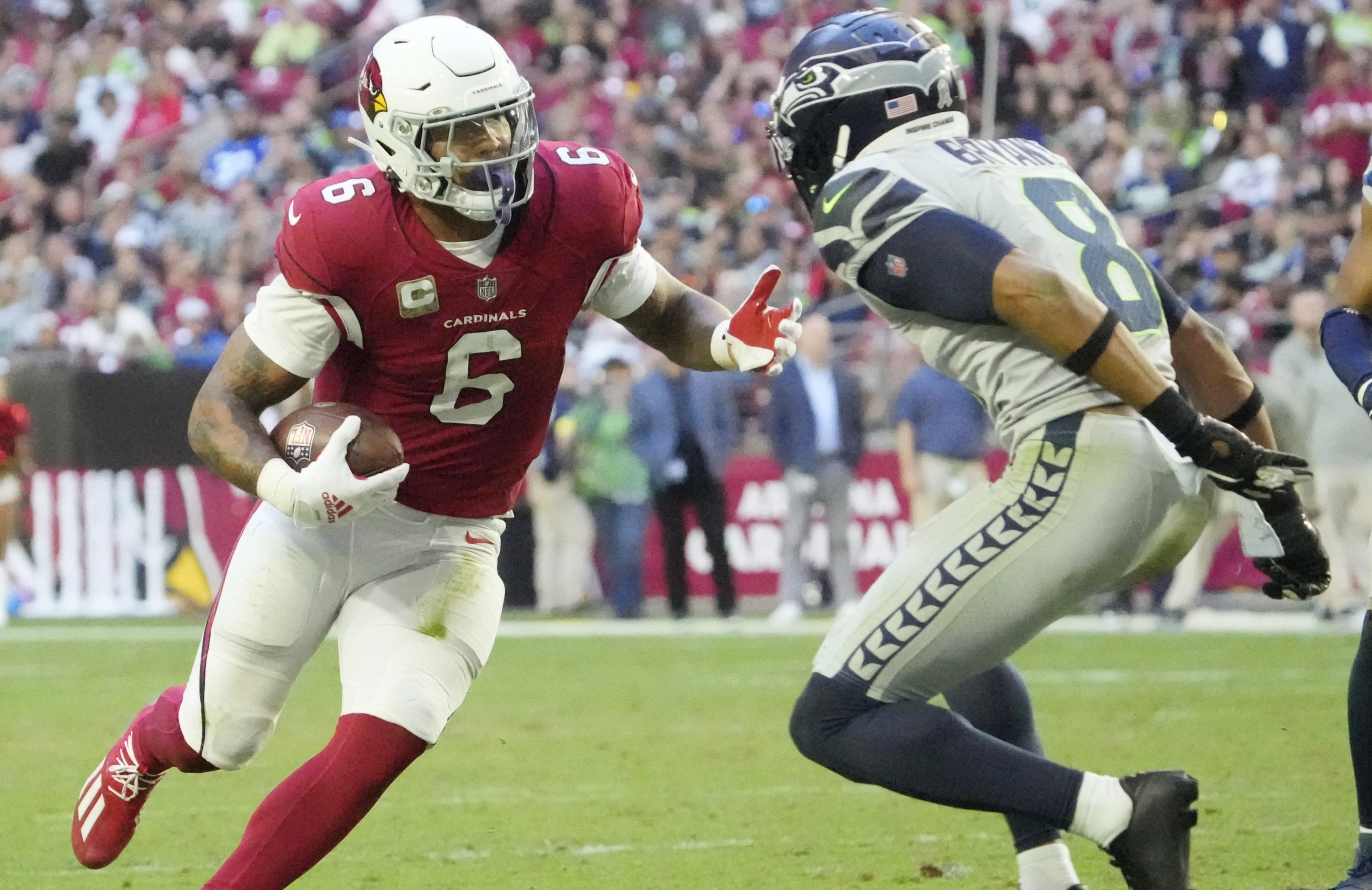 Arizona Cardinals running back James Conner (6) runs against Seattle Seahawks cornerback Coby Bryant (8) during the fourth quarter at State Farm Stadium.