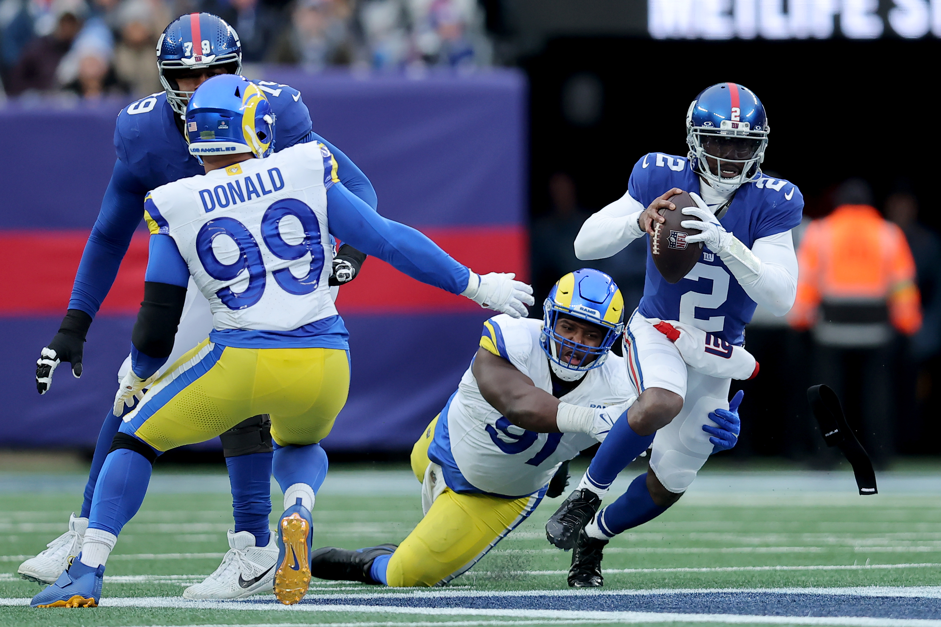 Dec 31, 2023; East Rutherford, New Jersey, USA; New York Giants quarterback Tyrod Taylor (2) is sacked by Los Angeles Rams defensive tackles Kobie Turner (91) and Aaron Donald (99) during the third quarter at MetLife Stadium.
