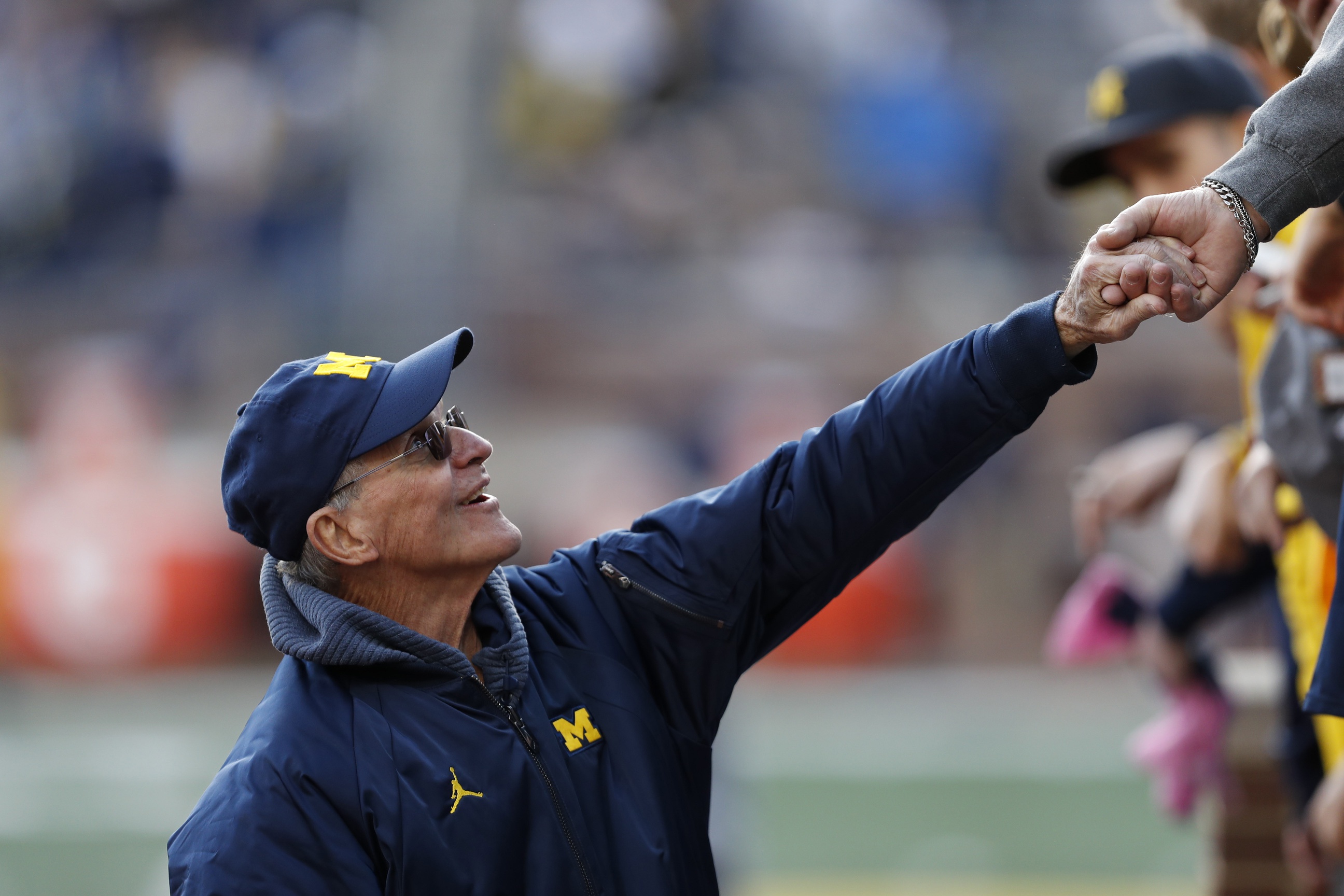 Jack Harbaugh, father of Michigan head coach Jim Harbaugh, shakes hands with Michigan fans