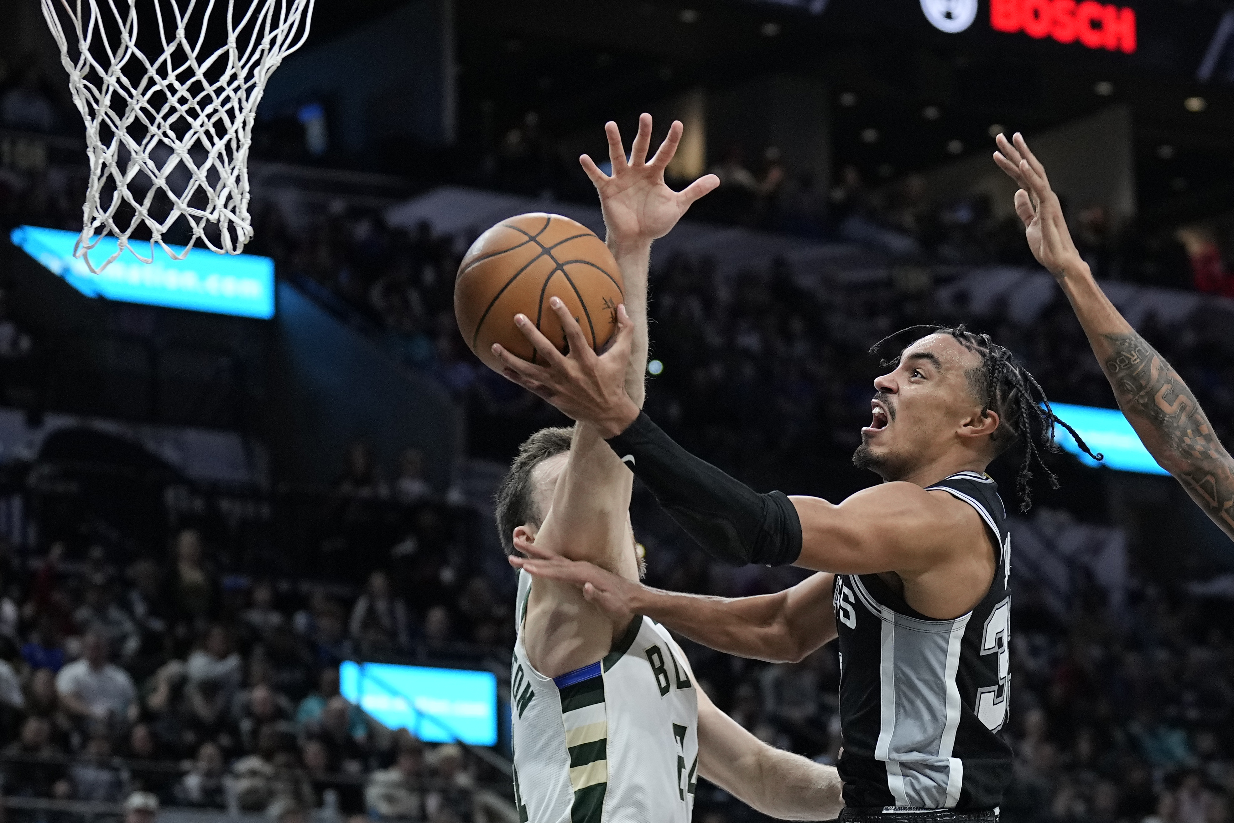 Jan 4, 2024; San Antonio, Texas, USA; San Antonio Spurs guard Tre Jones (33) drives to the basket while defended by Milwaukee Bucks guard Pat Connaughton (8) during the second half at Frost Bank Center.
