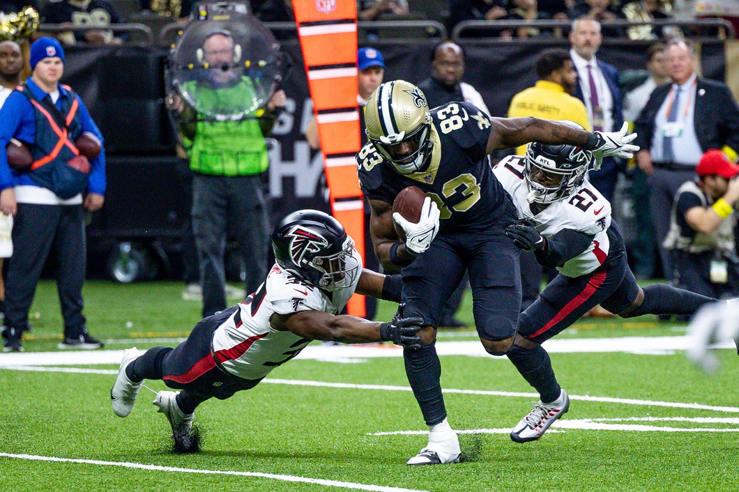 New Orleans Saints tight end Juwan Johnson (83) breaks the tackle attempts of Atlanta Falcons safeties Richie Grant (27) and Erik Harris (23). Mandatory Credit: Stephen Lew-USA TODAY Sports