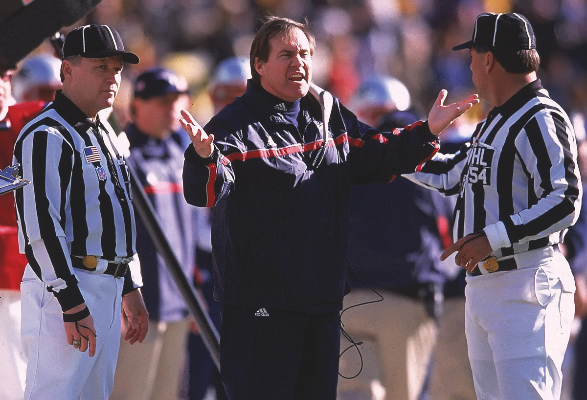 Bill Belichick puts his hands out toward two referees as he talks, visibly frustrated