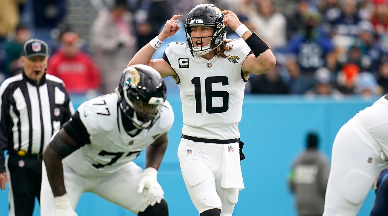 Trevor Lawrence signals by pointing to his helmet before taking a snap