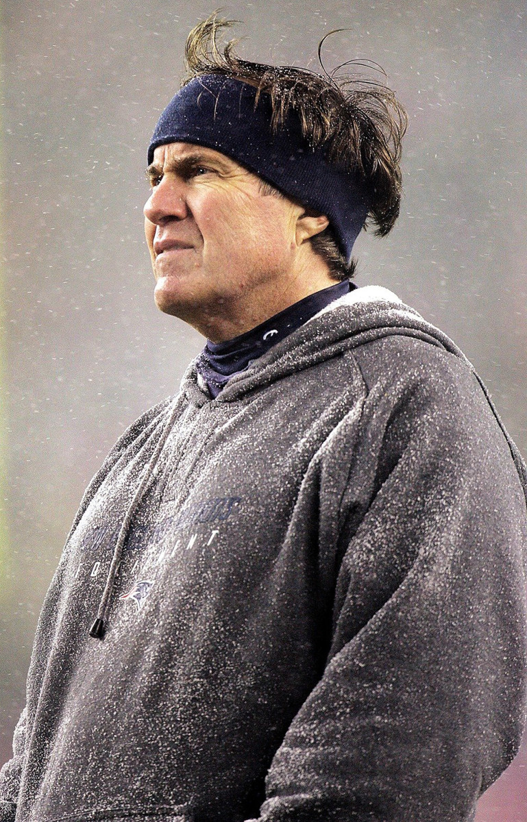 Bill Belichick stands in the snow.