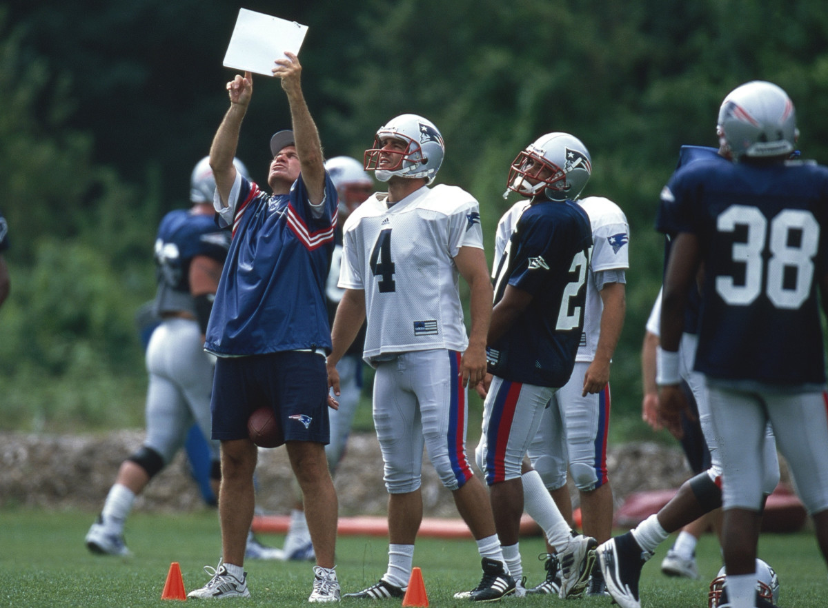 Belichick holds up a piece of paper for kicker Adam Vinatieri to look at in practice.