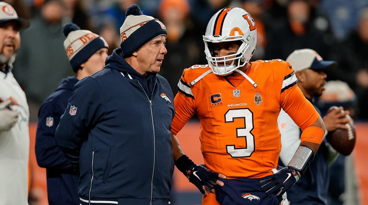 Denver Broncos head coach Sean Payton speaks with quarterback Russell Wilson during a game.