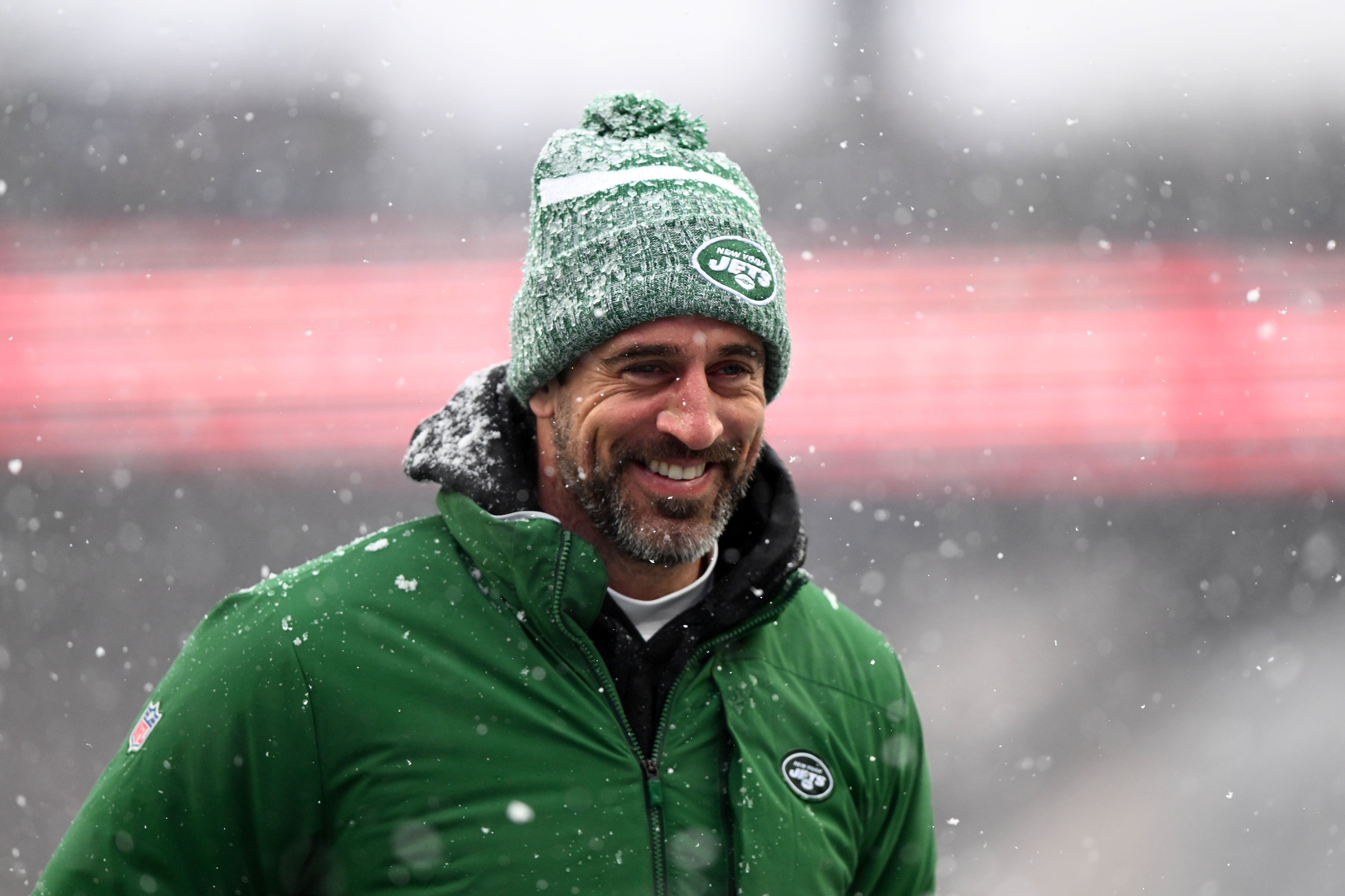 Aaron Rodgers smiles walking on the field