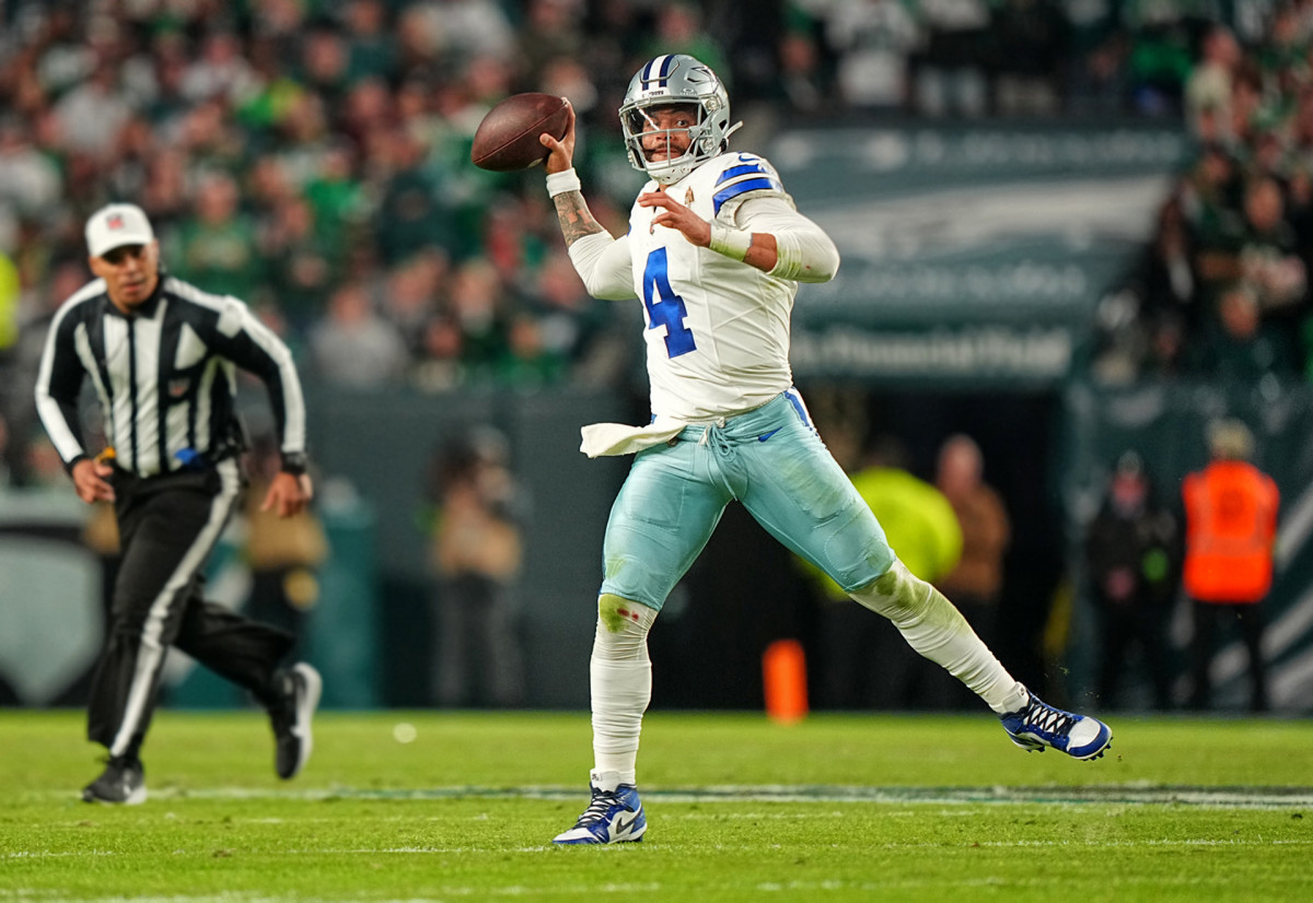 Dak Prescott throws the ball with one foot in the air