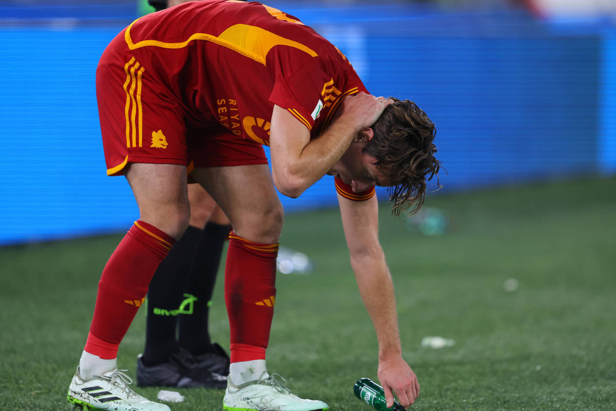 Roma defender Edoardo Bove pictured holding the back of his neck after being struck by a beer bottle thrown from the crowd during a game against Lazio in January 2024