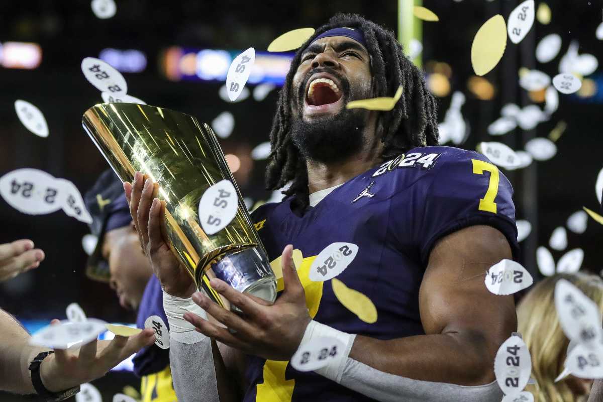 Michigan running back Donovan Edwards (7) picks up the trophy to celebrate 34-13 win over Washington at the national championship game at NRG Stadium in Houston on Monday, Jan. 8, 2024.