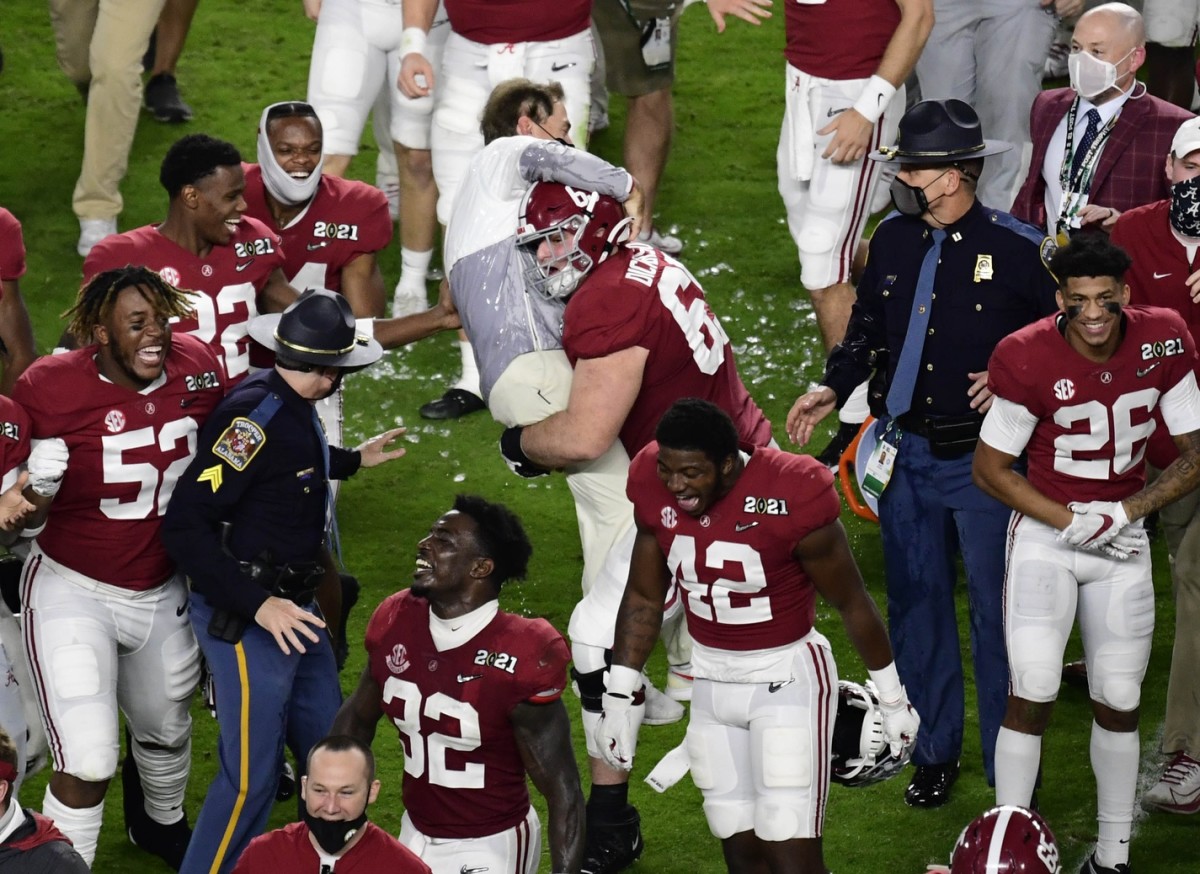 Philadelphia Eagles lineman Landon Dickerson gives his former coach, Nick Saban, a lift after the University of Alabama won the national title in Dickerson's final season with the Tide.