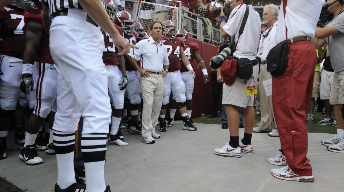 Nick Saban waits with his Alabama football players to run out onto the field.