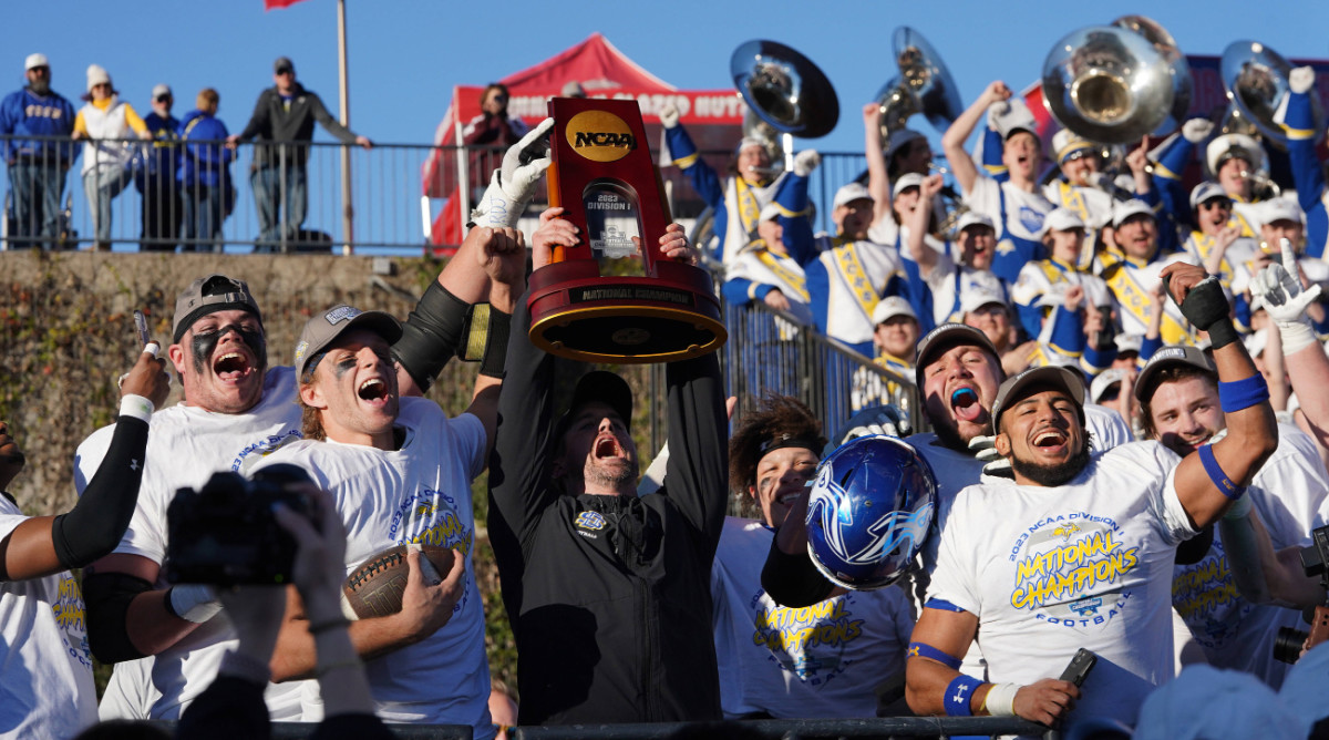 South Dakota State coach Jimmy Rogers hoists the FCS national championship trophy.