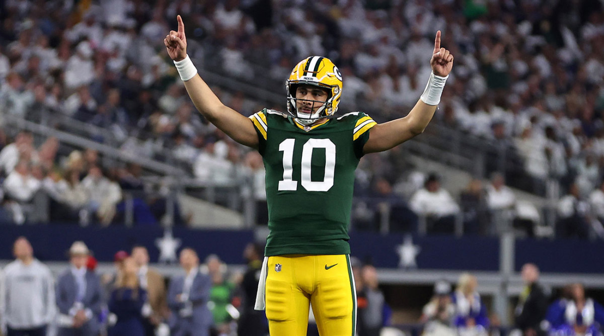 Jordan Love stands with both hands pointing up after throwing a touchdown against the Cowboys.