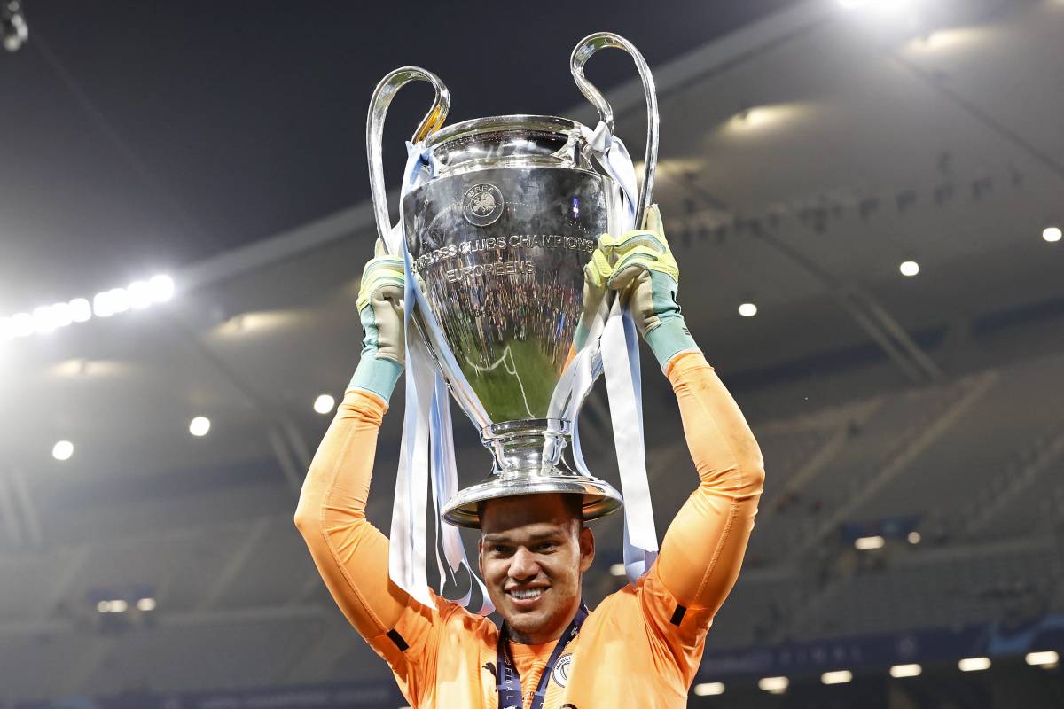 Manchester City goalkeeper Ederson pictured holding the UEFA Champions League trophy in June 2023