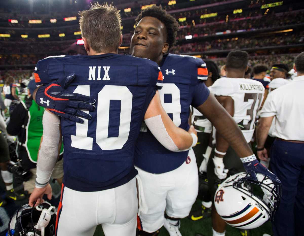 Bell embracing then Auburn starting quarterback Bo Nix after their season-opening win over the Oregon Ducks (1st Sept., 2019)