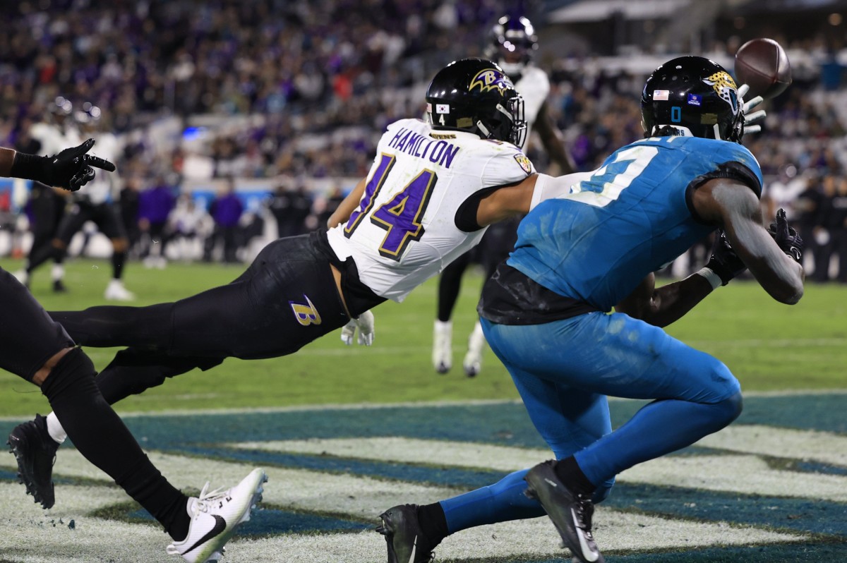 Baltimore Ravens safety Kyle Hamilton (14) pressures as Jacksonville Jaguars wide receiver Calvin Ridley (0) catches the ball but is ruled an incomplete pass during the fourth quarter of a regular season NFL football matchup Sunday, Dec. 17, 2023 at EverBank Stadium in Jacksonville, Fla.
