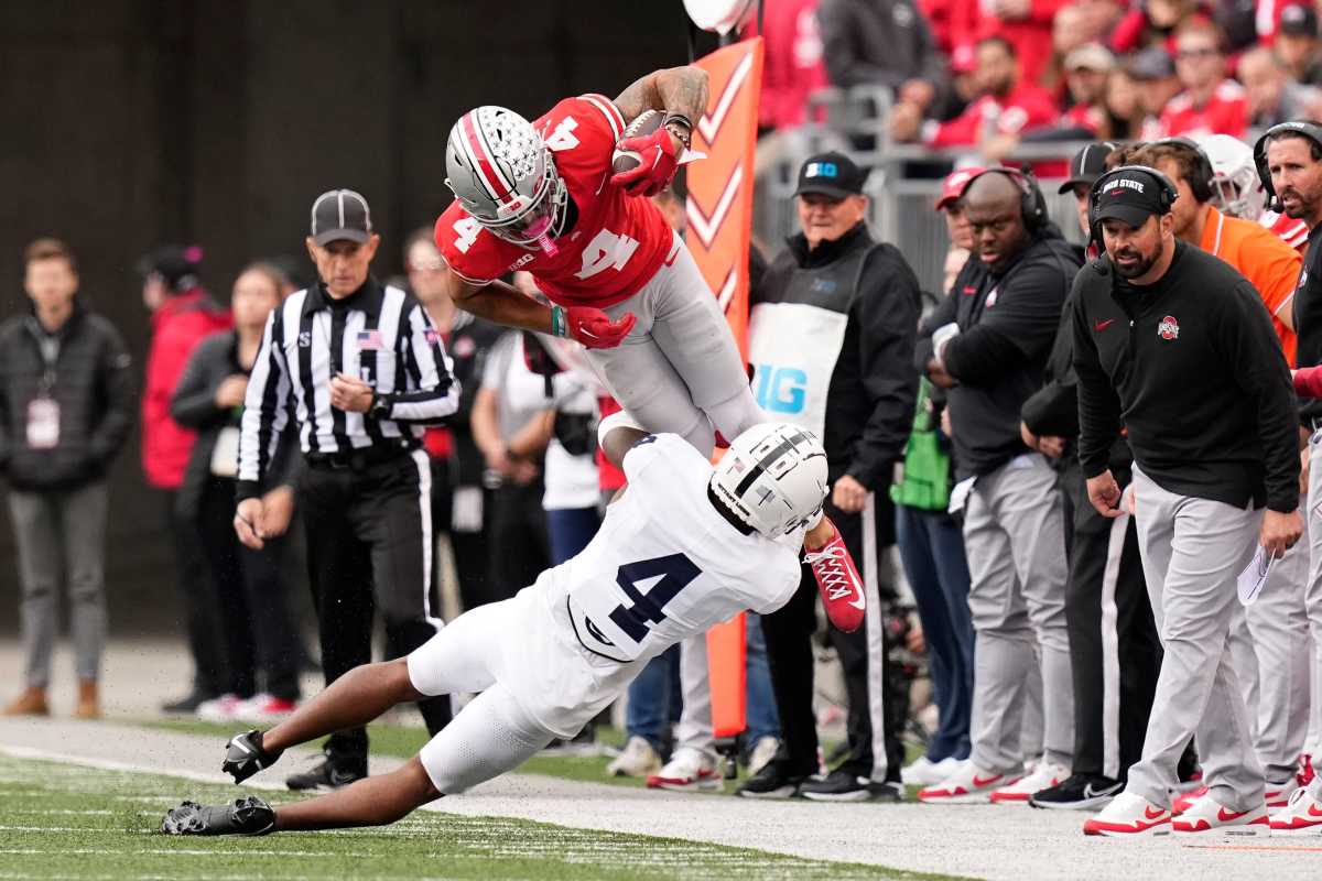 Kalen King grabs the leg of a OSU receiver who is in the air catching the ball
