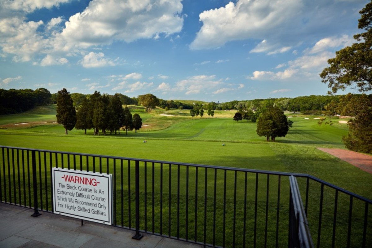 An iconic warning sign advises golfers of the impending difficulty as they approach the first tee at Bethpage State Park's Black Course.