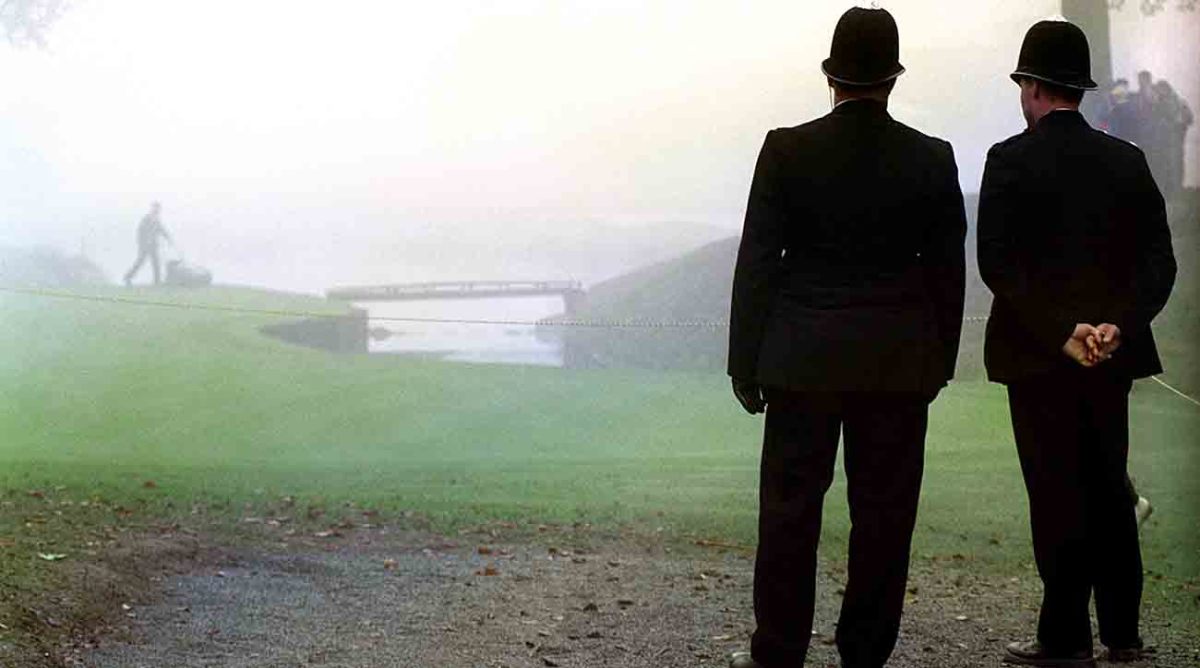 Fog shrouds the course as policemen watch ground staff prepare the greens for the delayed start to the 1993 Ryder Cup.