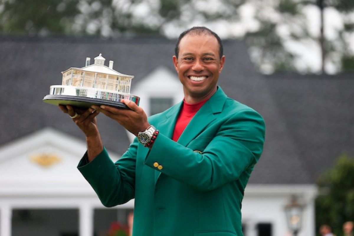 Tiger Woods shows off his 5th green jacket and the Masters trophy.