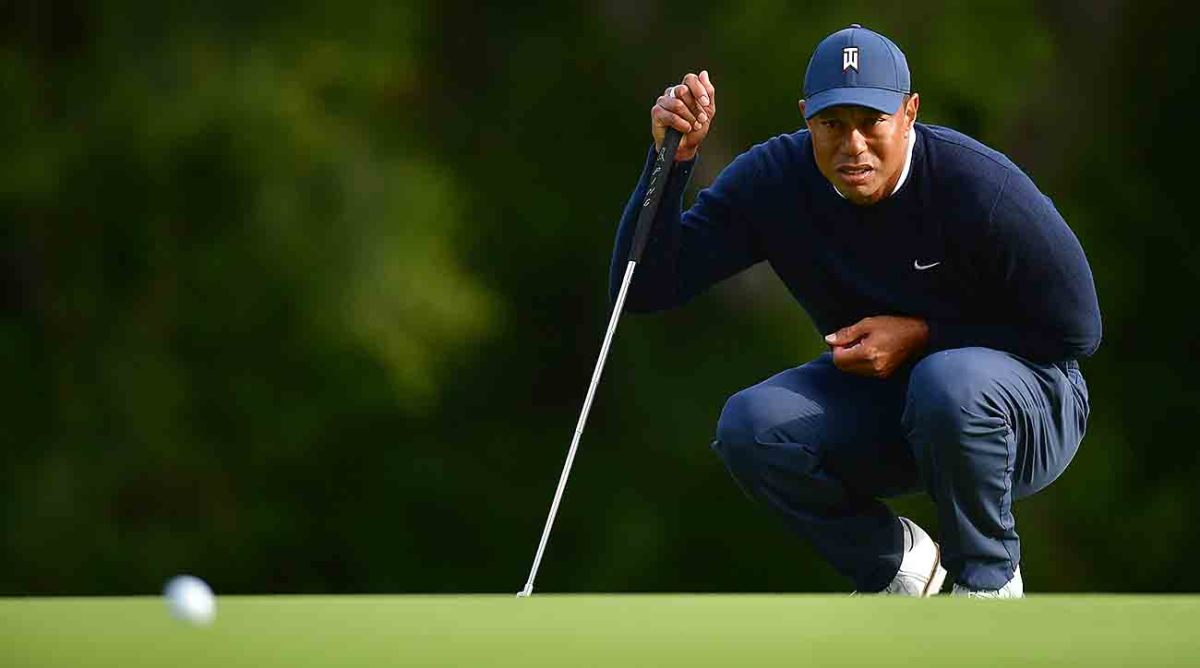 Tiger Woods squats to look at a putt during the first round of the 2023 Genesis Invitational.