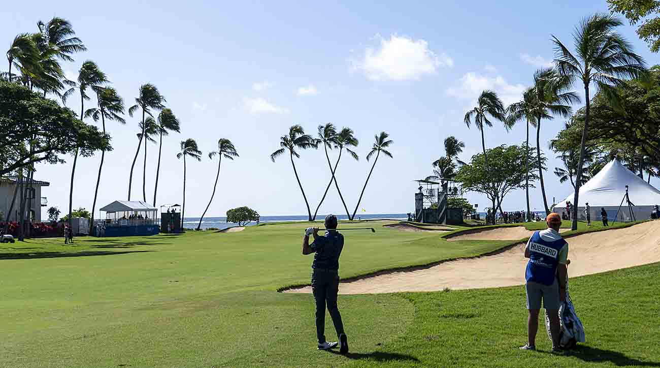 Mark Hubbard hits a shot with the iconic Waialae Country Club tree-form "W" in the background at the 2023 Sony Open in Hawaii.