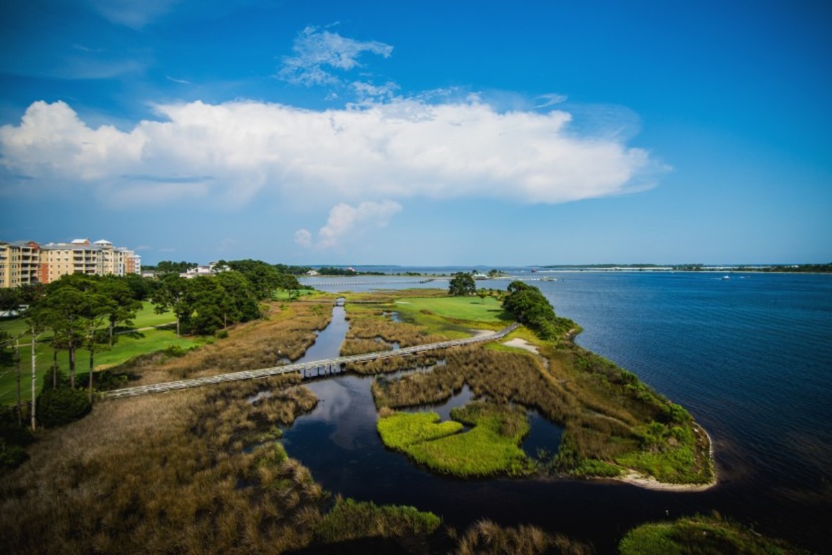 The par-4 fifth hole is considered the signature due to two shots over a marsh and its setting. The second is an approach into a green that is protected by trees and St. Andrew's Bay.