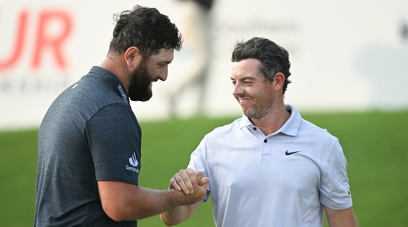Jon Rahm shakes hands with Rory McIlroy on the 18th green during the first round of the TOUR Championship golf tournament at East Lake Golf Club.