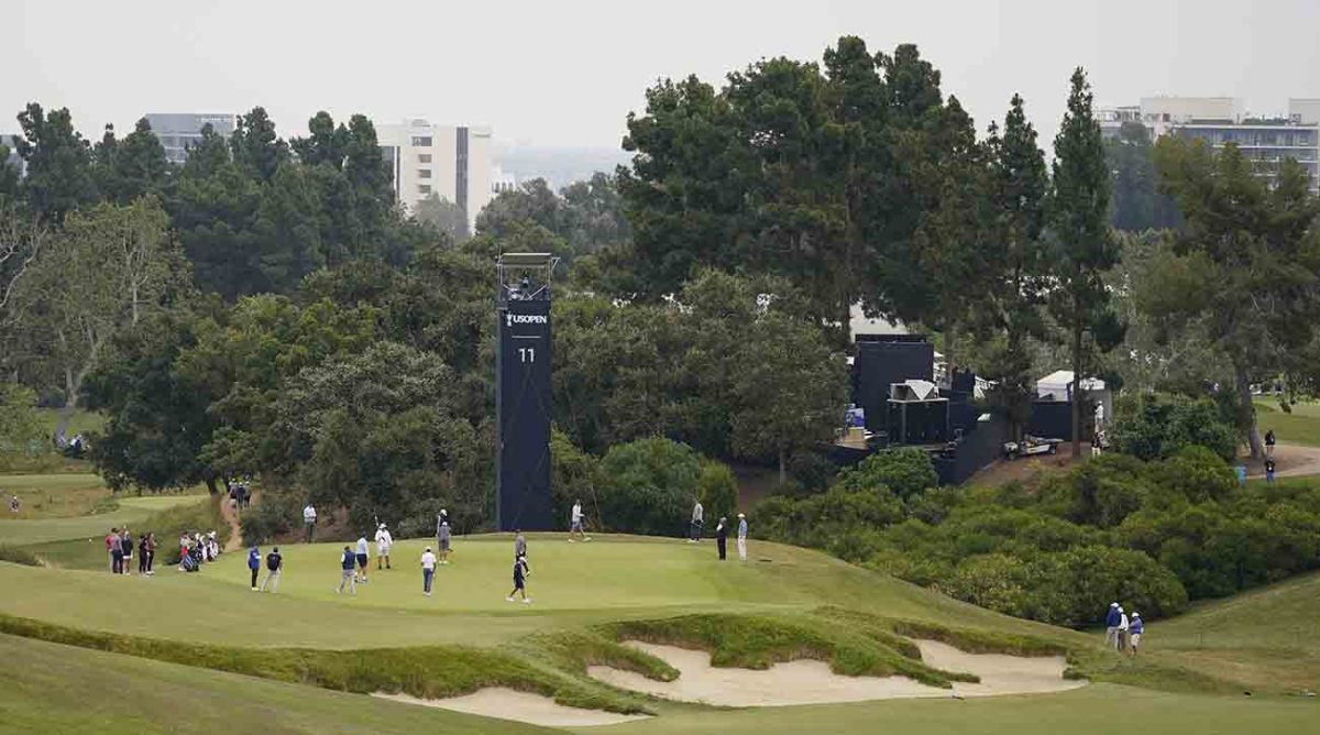 Players and caddies study the 11th green during a practice day at the 2023 U.S. Open.