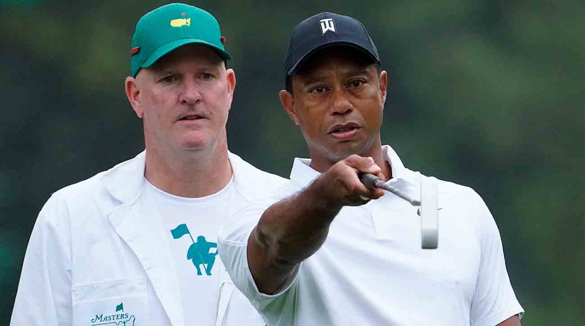 Tiger Woods looks at a green with caddie Joe LaCava at the 2022 Masters.